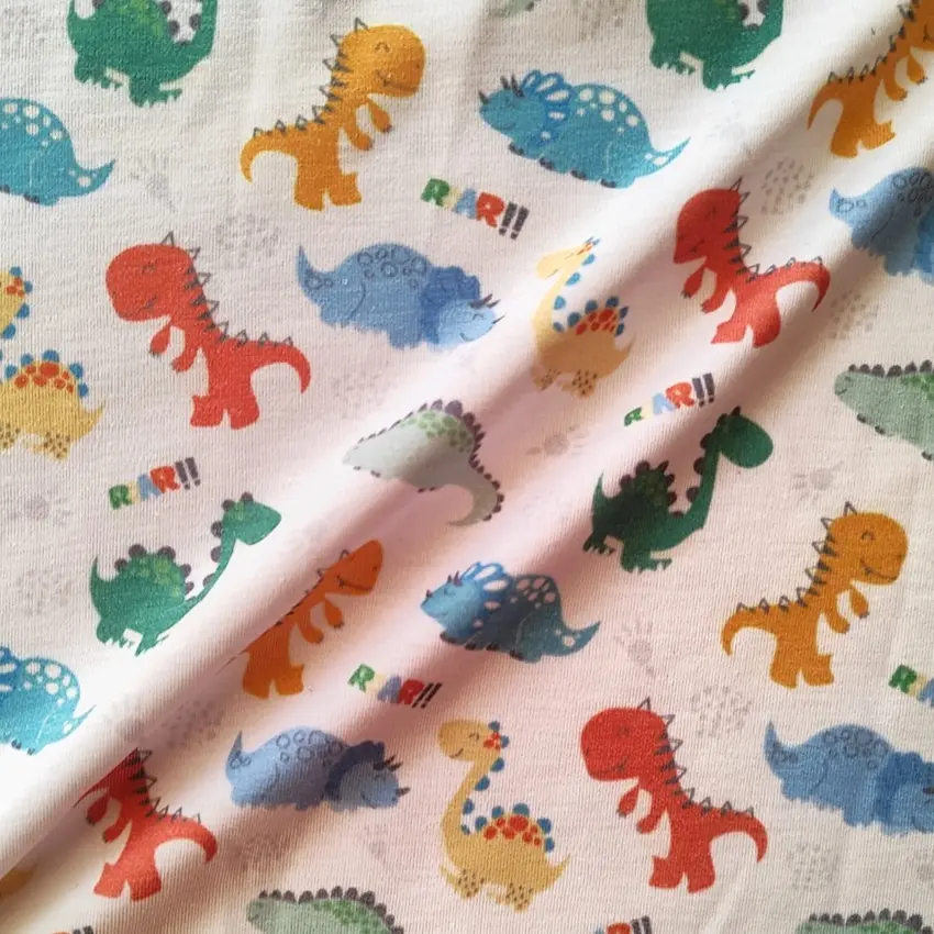 پارچه تریکو پنبه ترکیبی طرح دایناسورهای رنگی